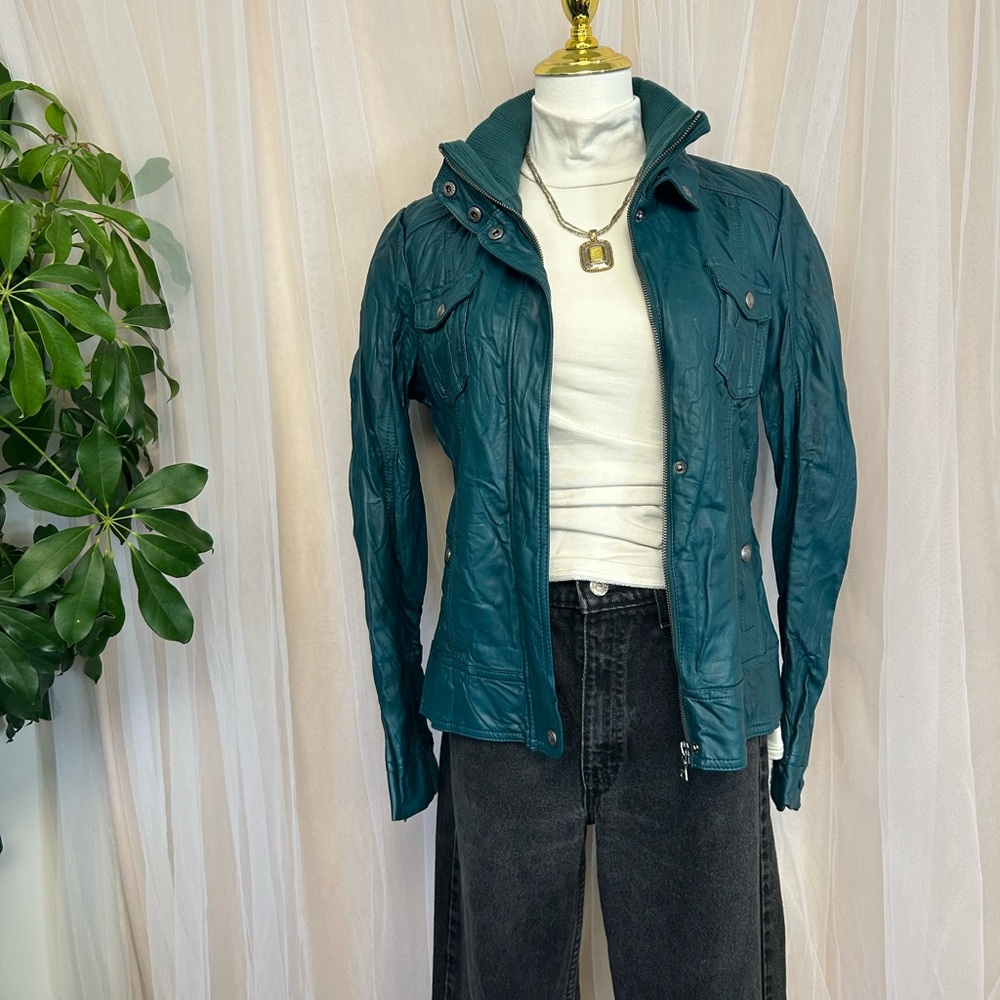 Guess teal colored faux leather jacket with zipper and button closures.